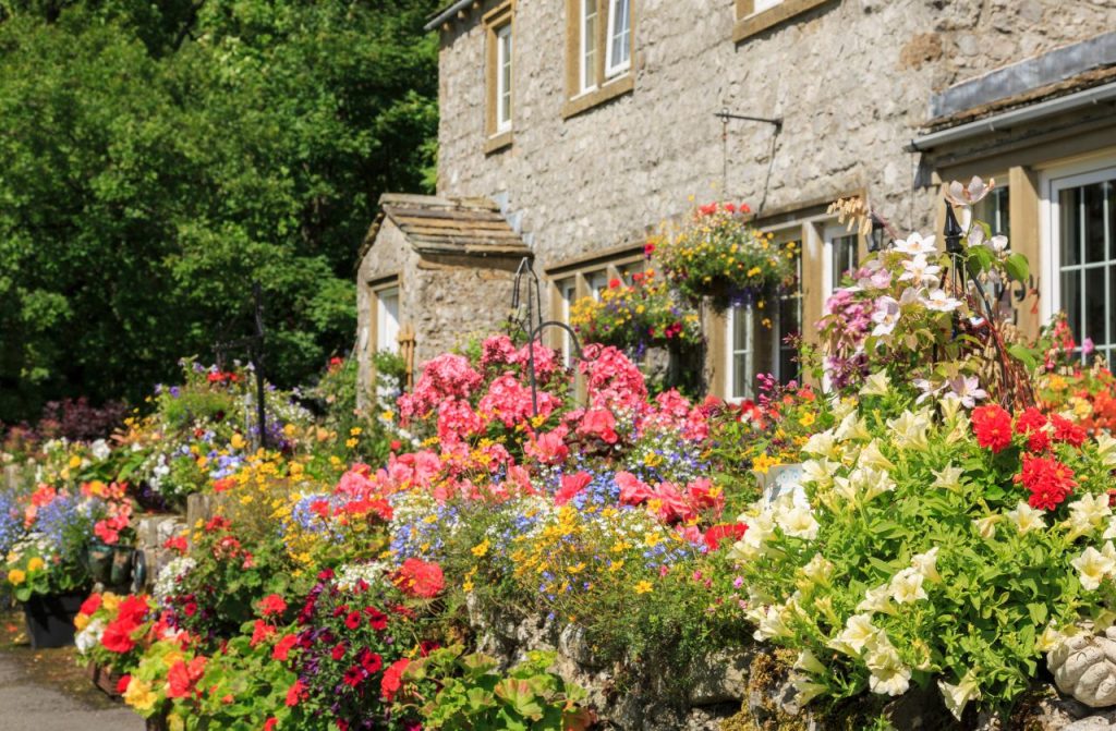An old english cottage surrounded by flowers